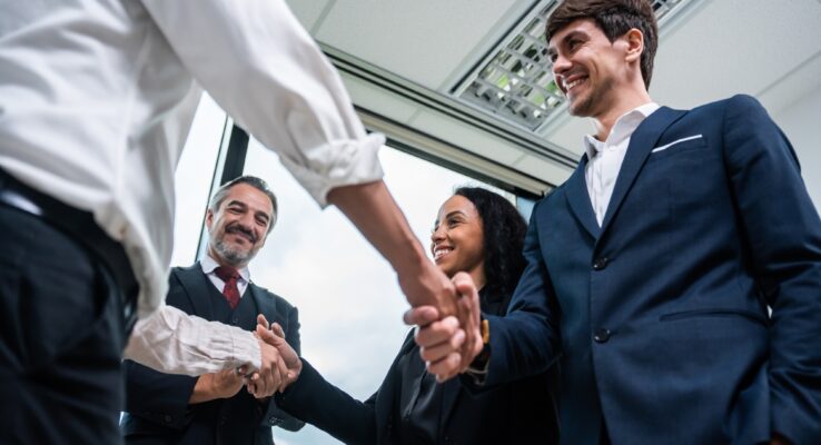 The Benefits of Partnering with One Company for Construction, Rental, and Maintenance 1 Caucasian businessman making a handshake together while stand in office.