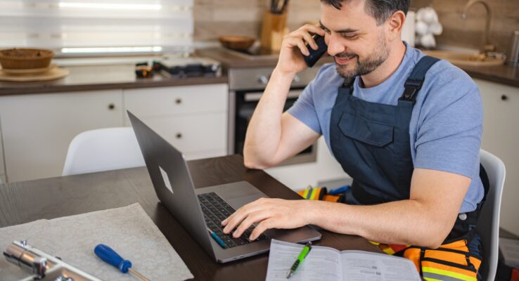 Abu Dhabi Tenant & Property Maintenance Handbook 1 Plumber working on laptop and talking on the phone