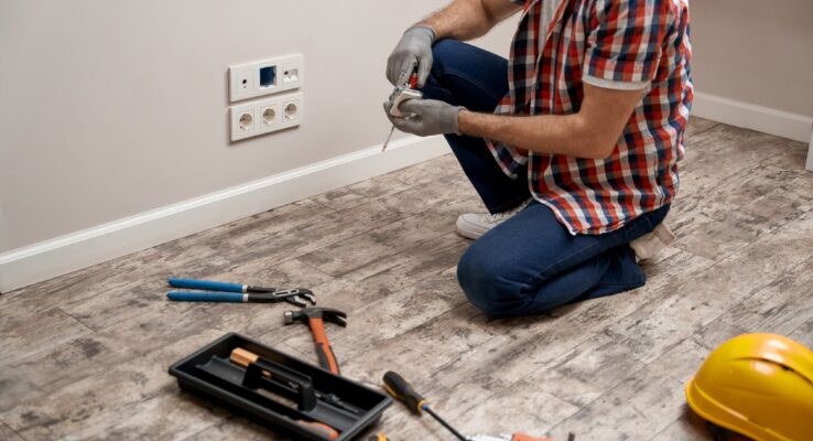 How Our Maintenance Team Handles Emergency Requests in Abu Dhabi 1 Young caucasian electrician putting power socket into wall