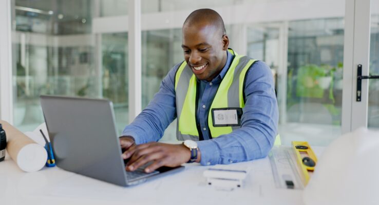 Typing architect, laptop and happy black man planning infrastructure design, floor plan or property